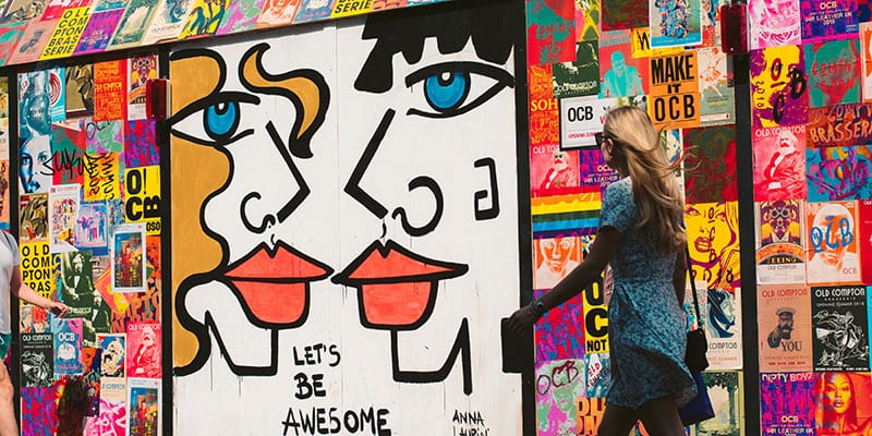 kvinna går förbi grafittivägg
