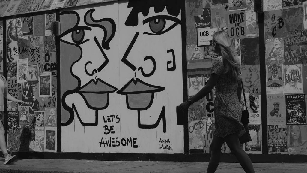 tjej går vid graffittivägg