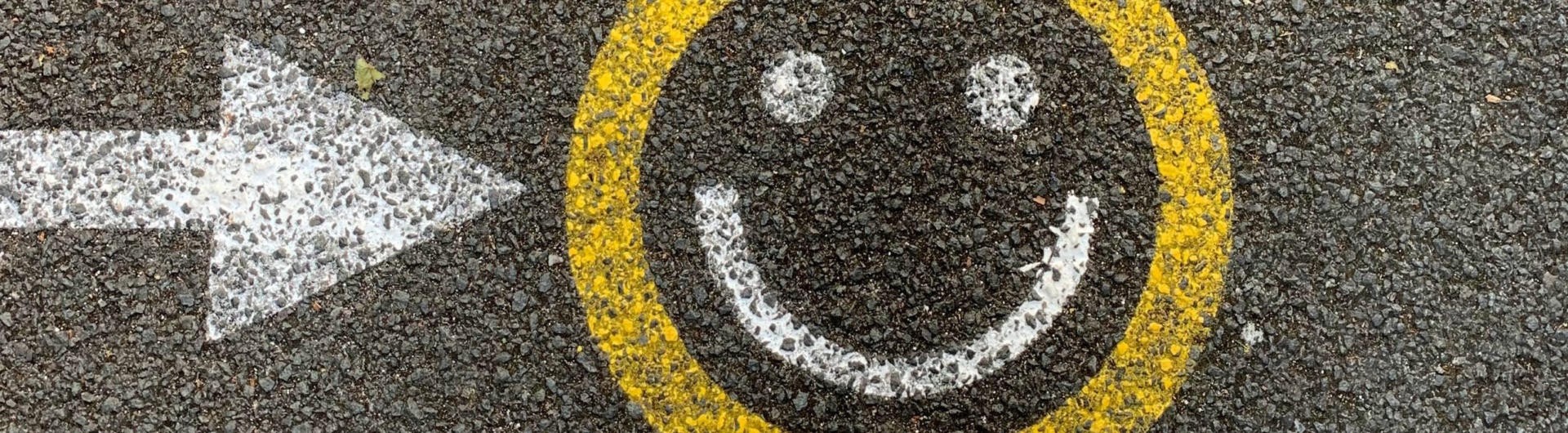En smiley som är målad på gatan som en symbol för en lyckad medarbebetarundersökning eller pulsmätning