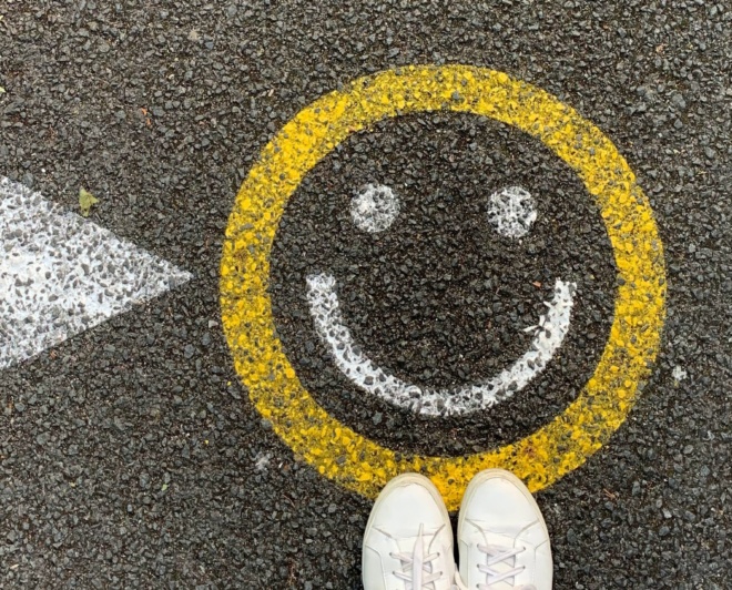 En smiley som är målad på gatan som en symbol för en lyckad medarbebetarundersökning eller pulsmätning