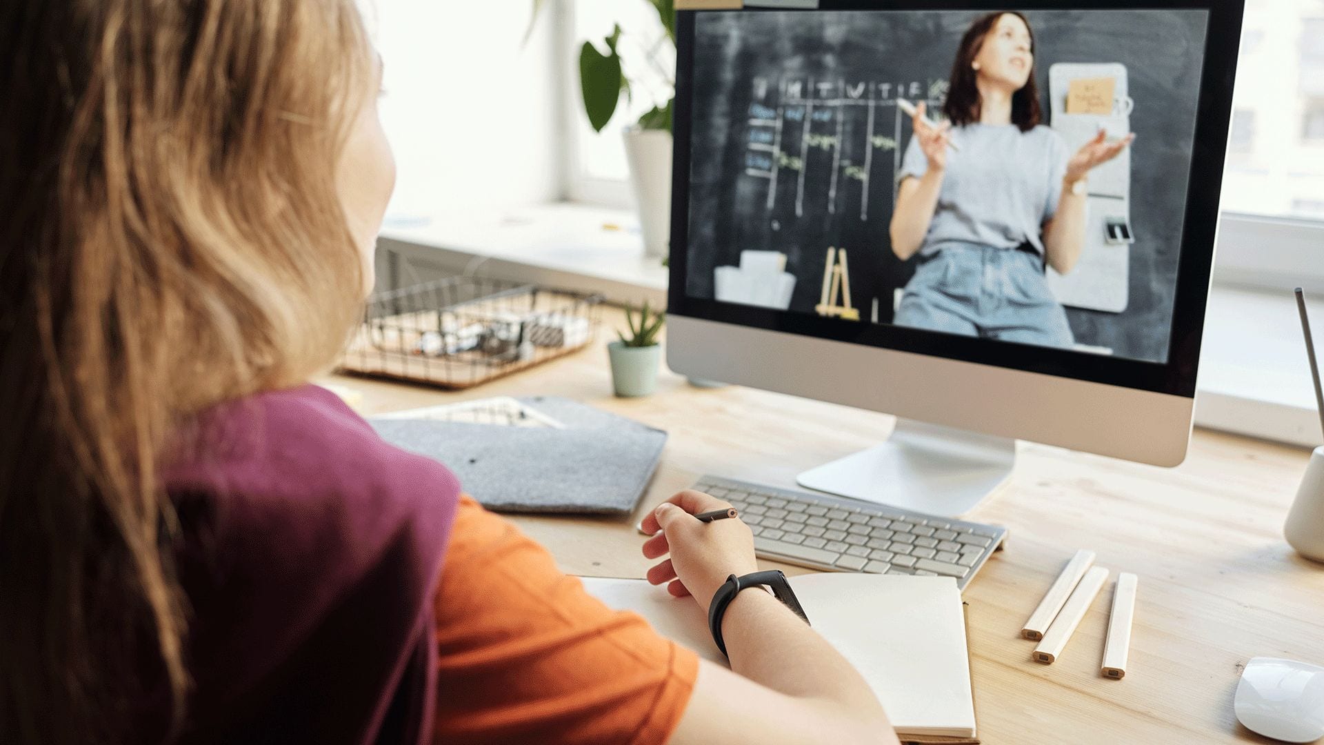 tjej sitter framför datorn och pluggar på distans genom att se på en digital lektion används som bild för att kontakta oss om man är intresserad av skolundersökningar