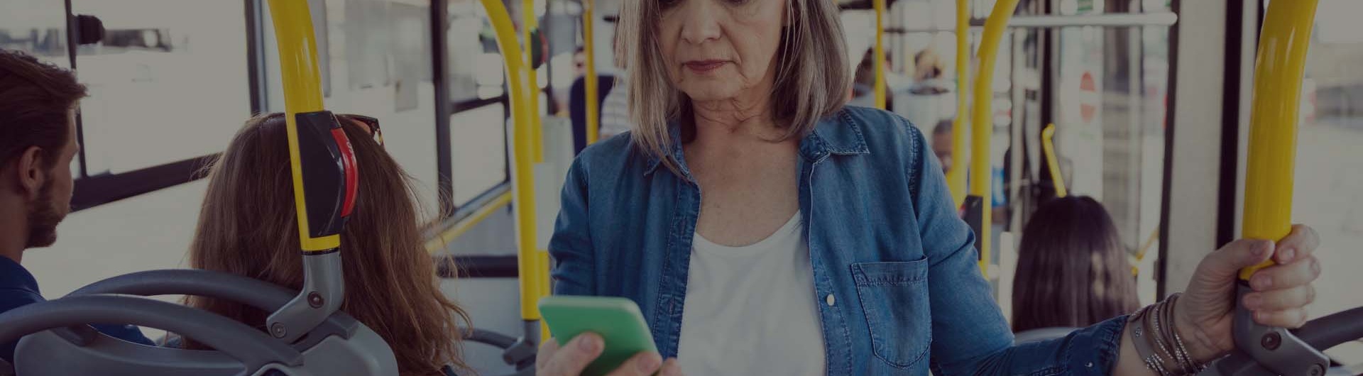 kvinna står på bussen och svarar på frågor i sin mobiltelefon