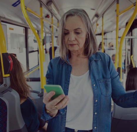 kvinna står på bussen och svarar på frågor i sin mobiltelefon