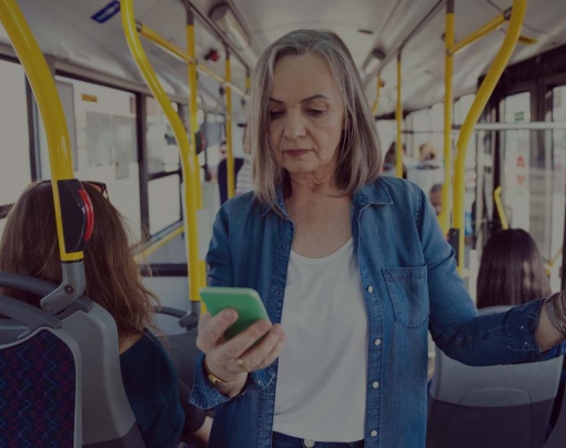 kvinna står på bussen och svarar på frågor i sin mobiltelefon