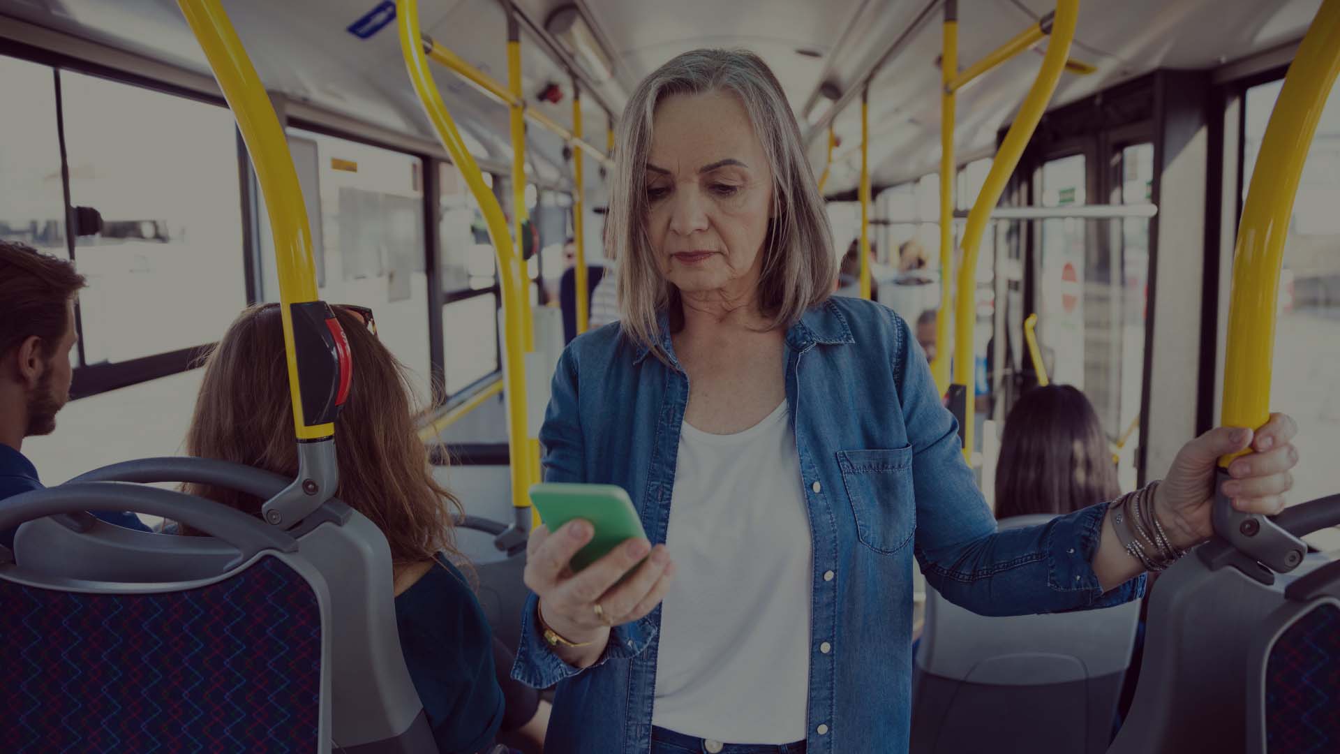 kvinna står på bussen och svarar på frågor i sin mobiltelefon