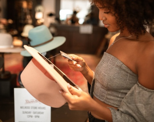 tjej undersöker priset på en hatt för att avgöra om hon vill köpa den eller inte